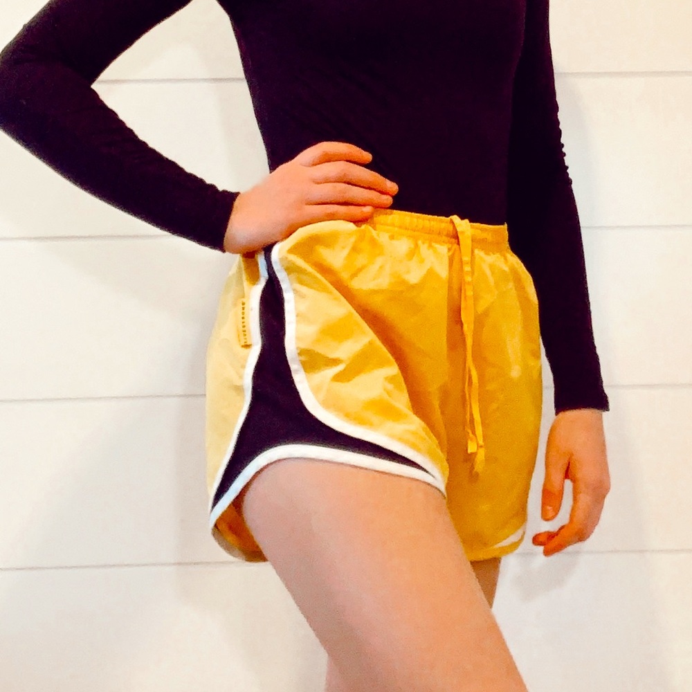 black, yellow, and white Nike running shorts